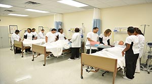 Groups of 4 students each practice nursing skills in the Skills Lab