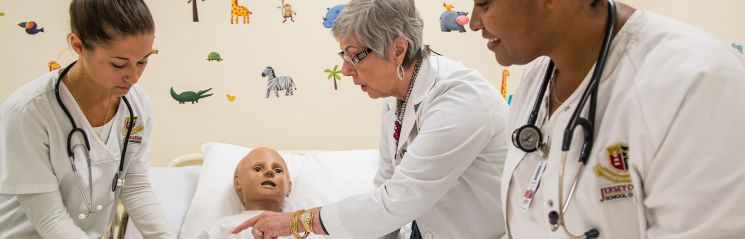 A nursing instructor at Jersey College demonstrates pediatric care to a class of nursing students.